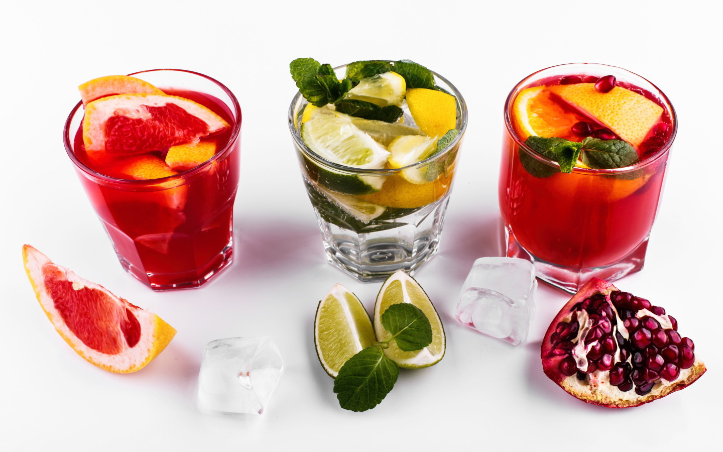 Стаканы с цитрусовыми коктейлями со льдом на белом фоне с фруктами