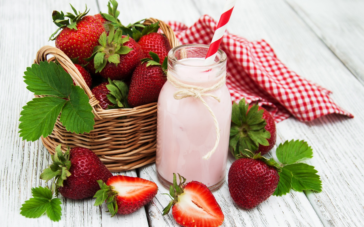 Банка с коктейлем на столе с ягодами клубники