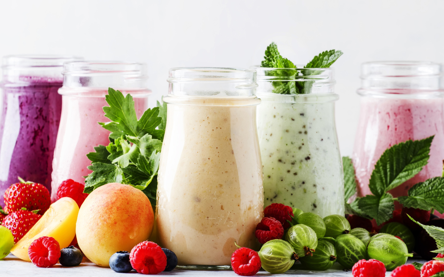 Банки со смузи на столе с ягодами 