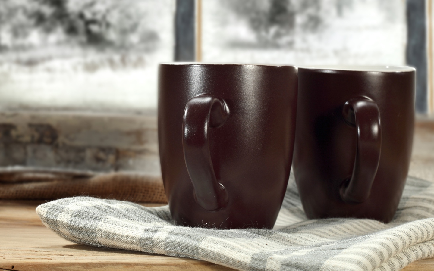 Две коричневые чашки кофе на столе с шарфом