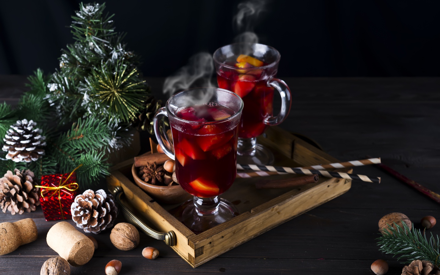 Два стакана горячего глинтвейна на столе с еловой веткой