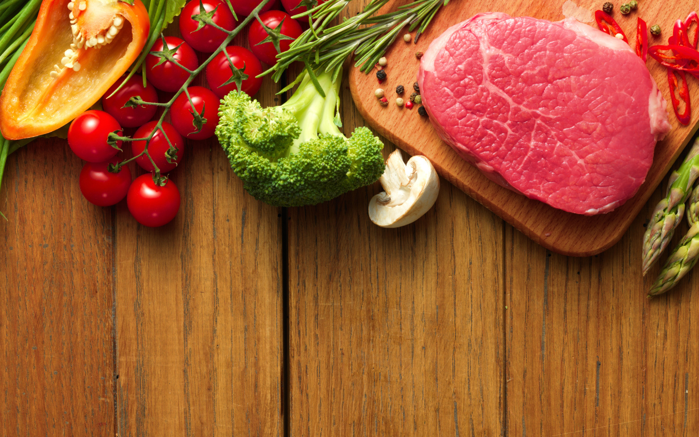 Кусок свежего мяса на столе с овощами и зеленью 