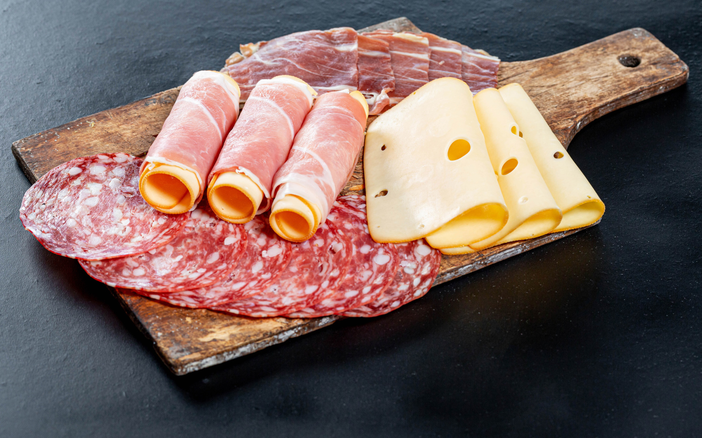 Ветчина на доске с колбасой и твердым сыром