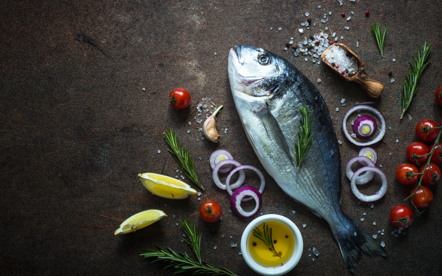 Свежая рыба на столе с овощами и специями 