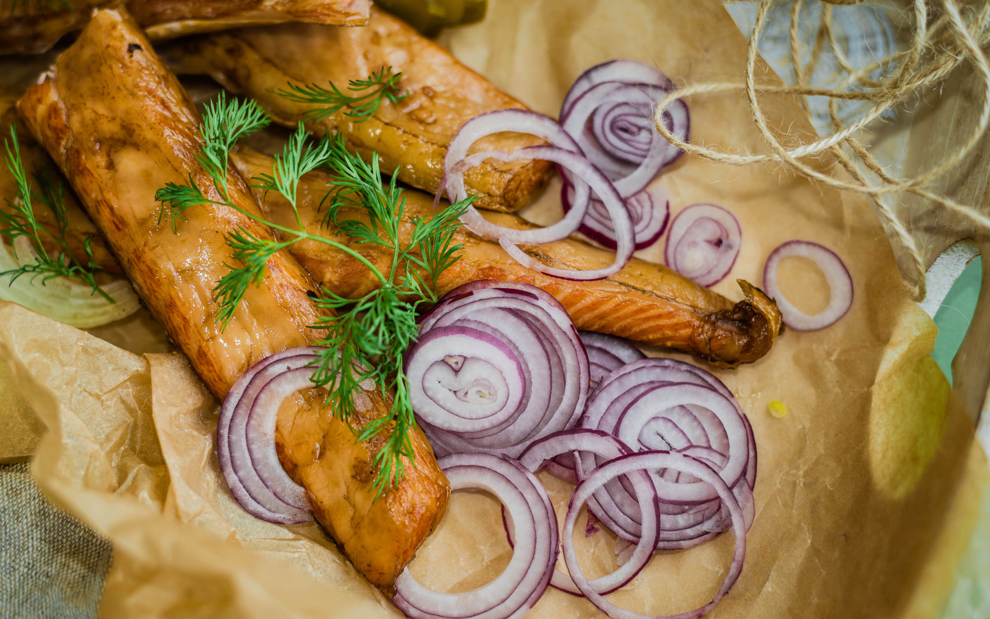 Копченое филе рыбы на бумаге с луком