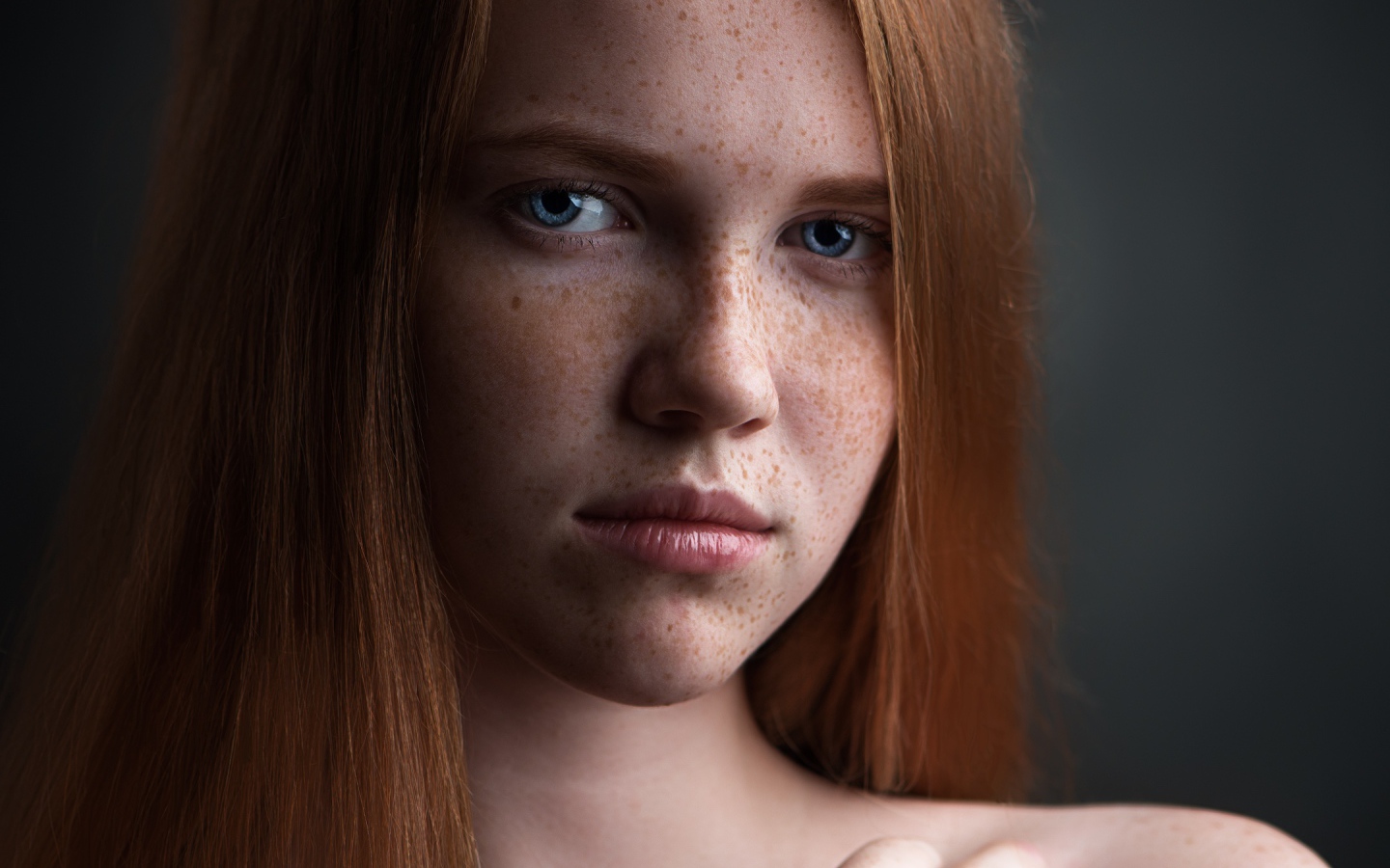 Красивая голубоглазая рыжеволосая девушка с веснушками