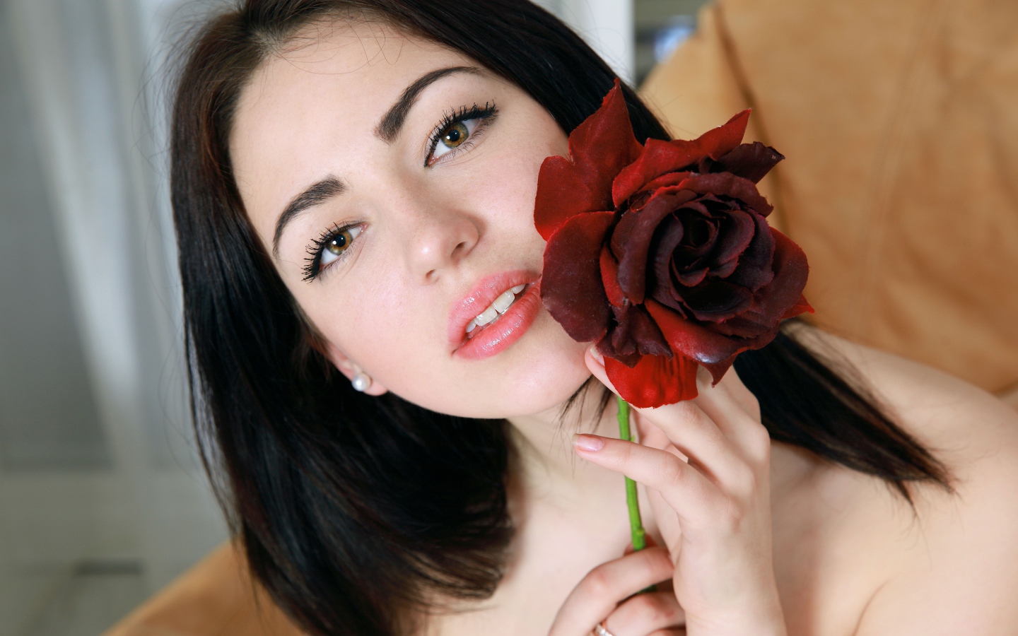 Красивая брюнетка с розой в руке крупным планом