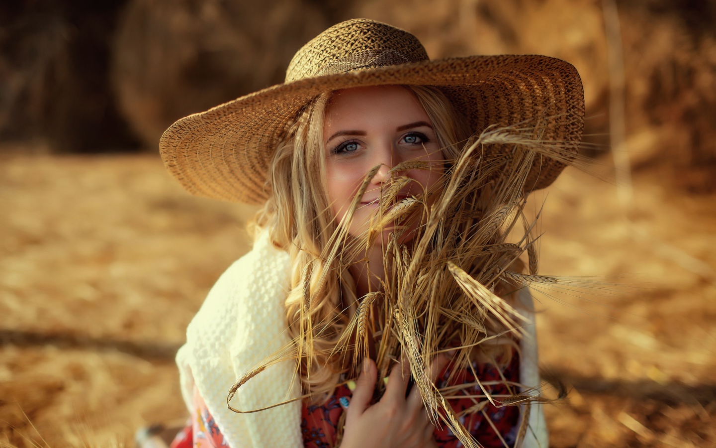 Красивая девушка в шляпе с колосьями в руке