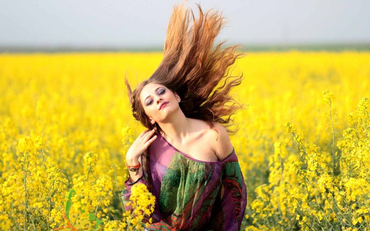 Красивая девушка на поле с желтыми цветами