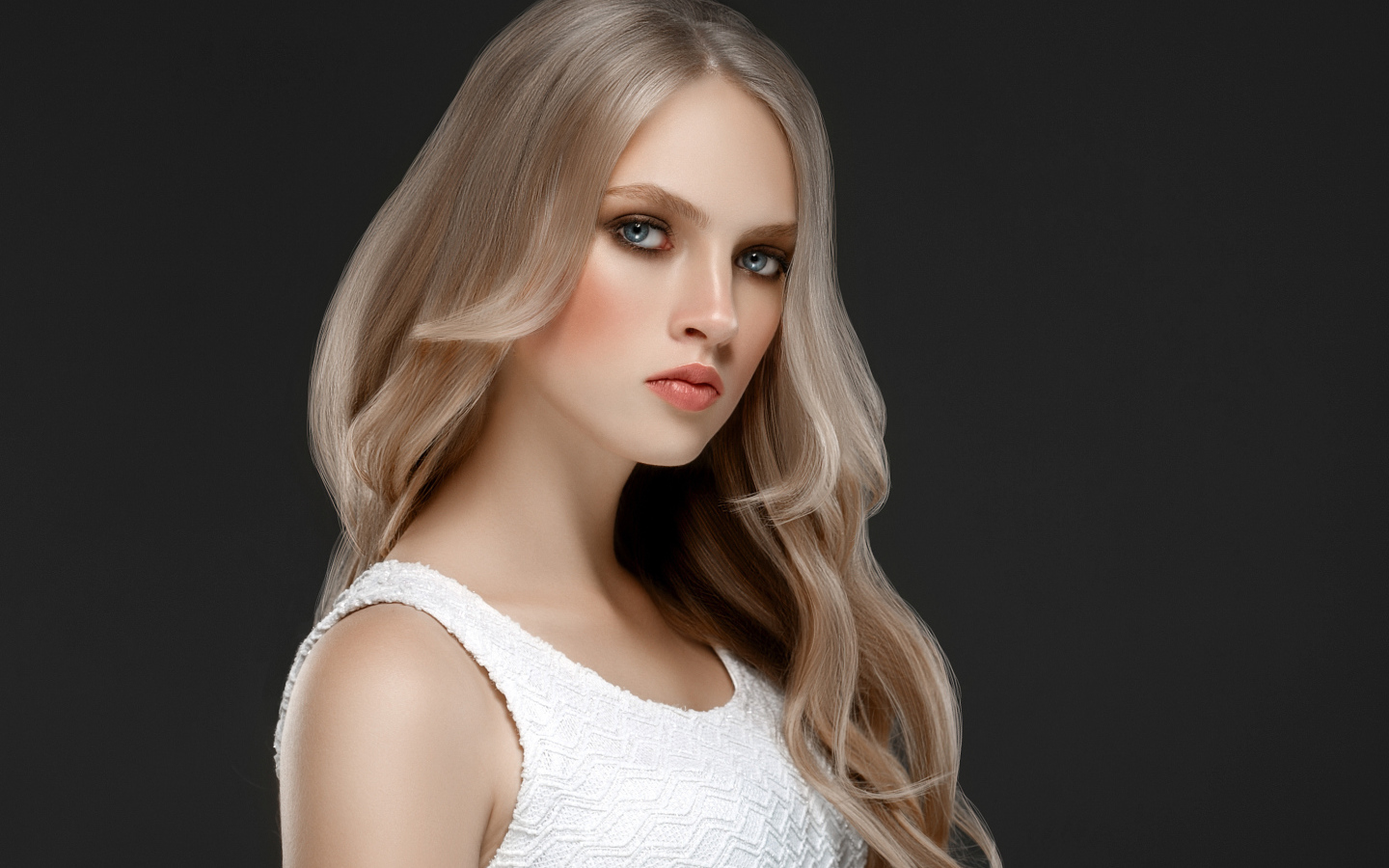 Красивая девушка с длинными  белыми волосами на сером фоне
