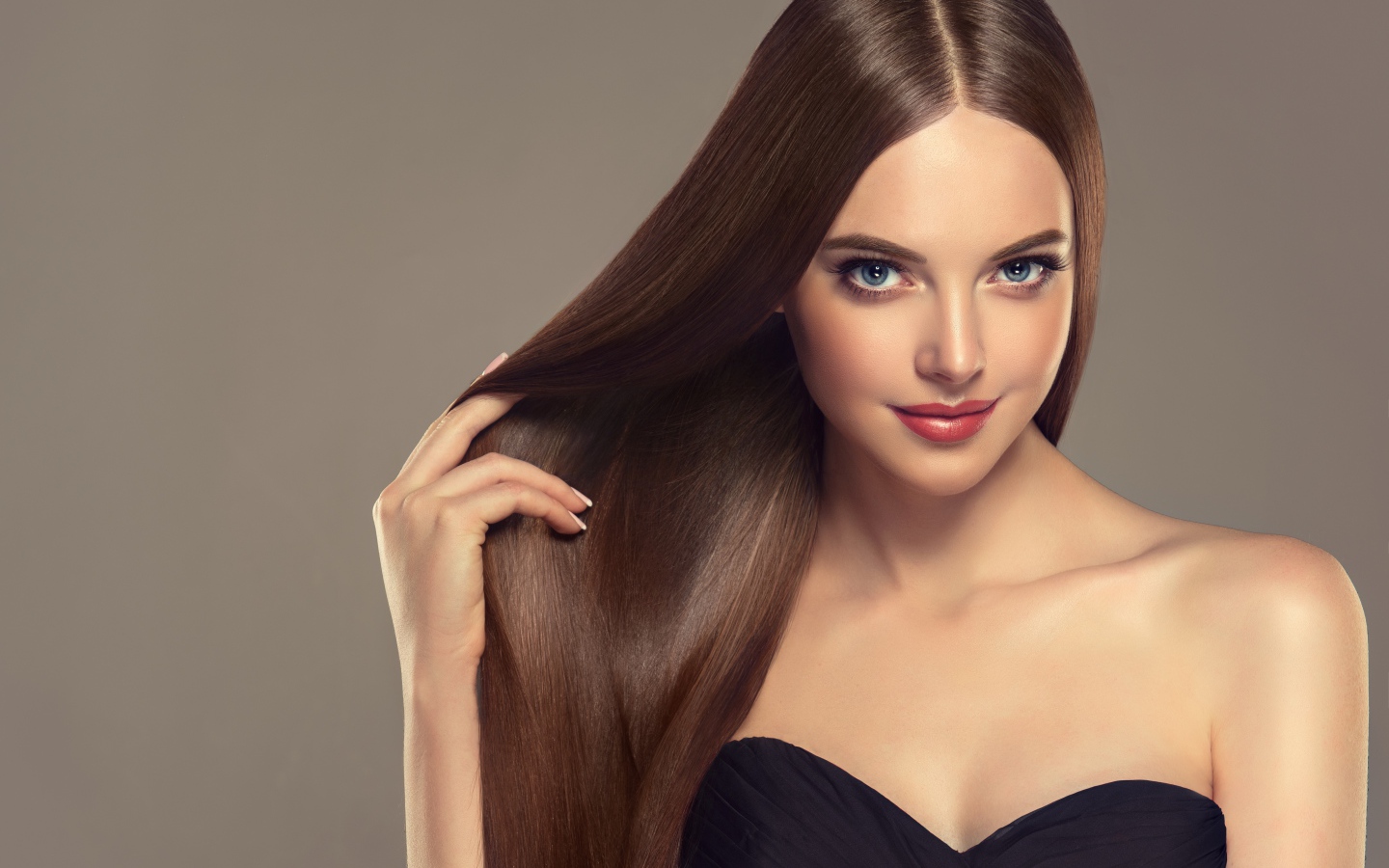 Красивая нежная длинноволосая голубоглазая девушка на сером фоне