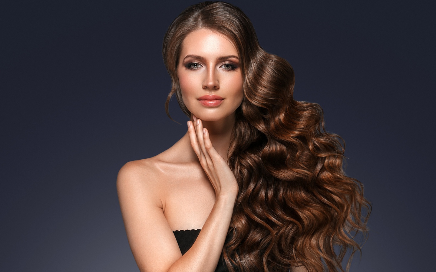 Стильная девушка с красивыми длинными волосами на сером фоне