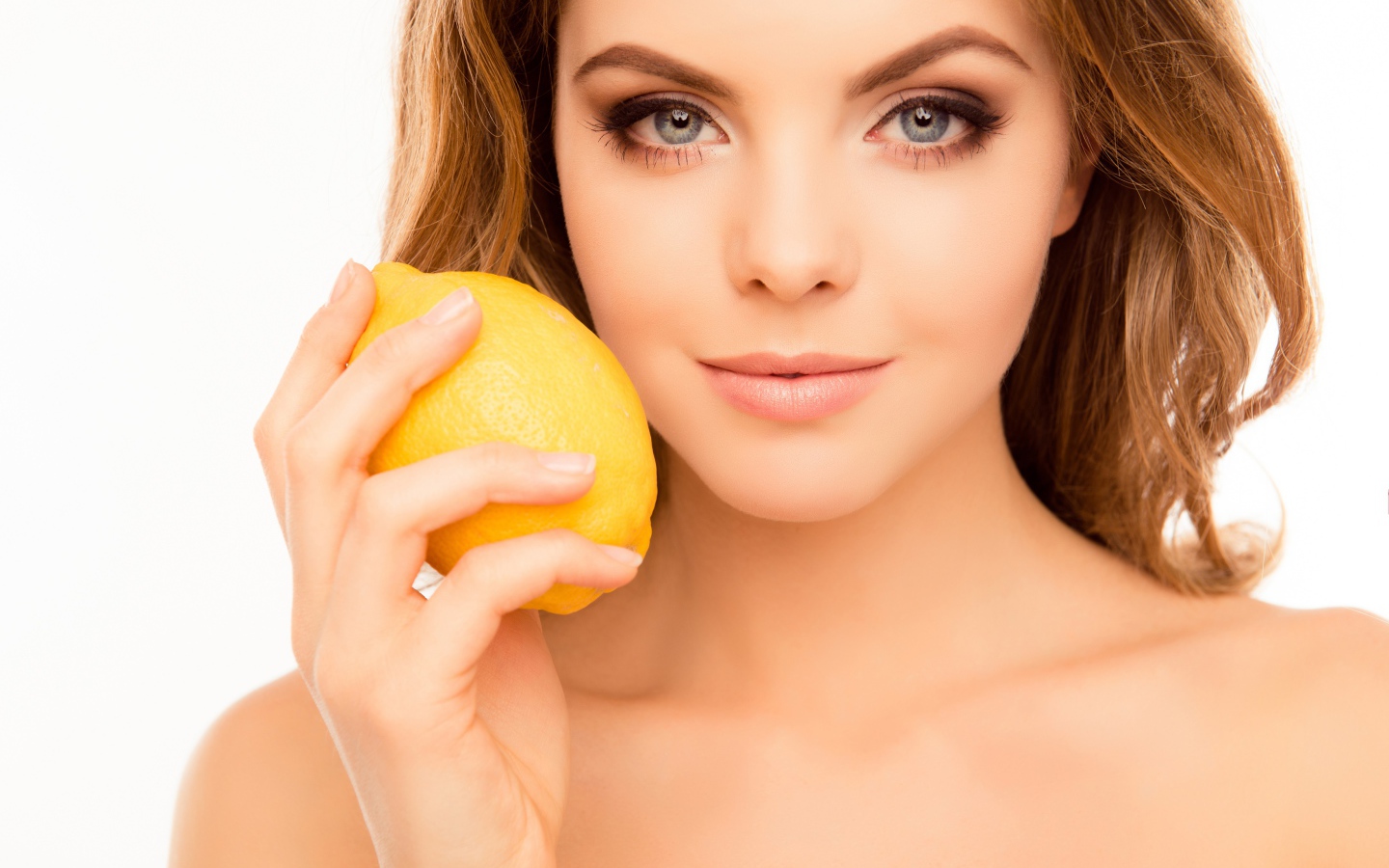 Нежная голубоглазая девушка с лимоном в руке