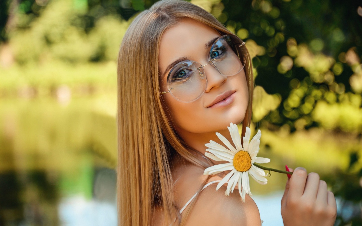 Девушка в очках с ромашкой в руке 