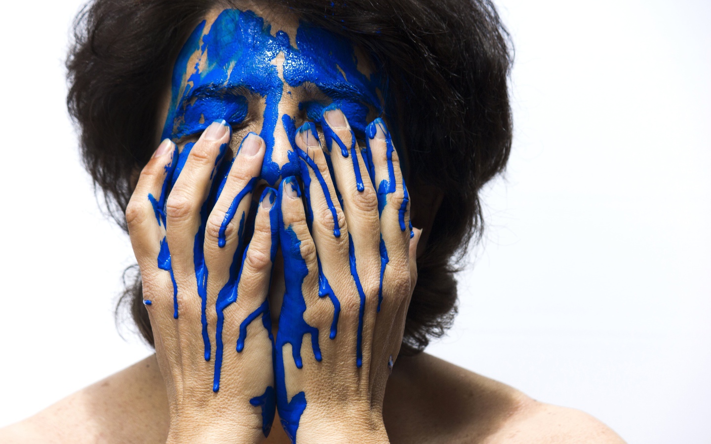 Лицо и руки женщины в синей краске