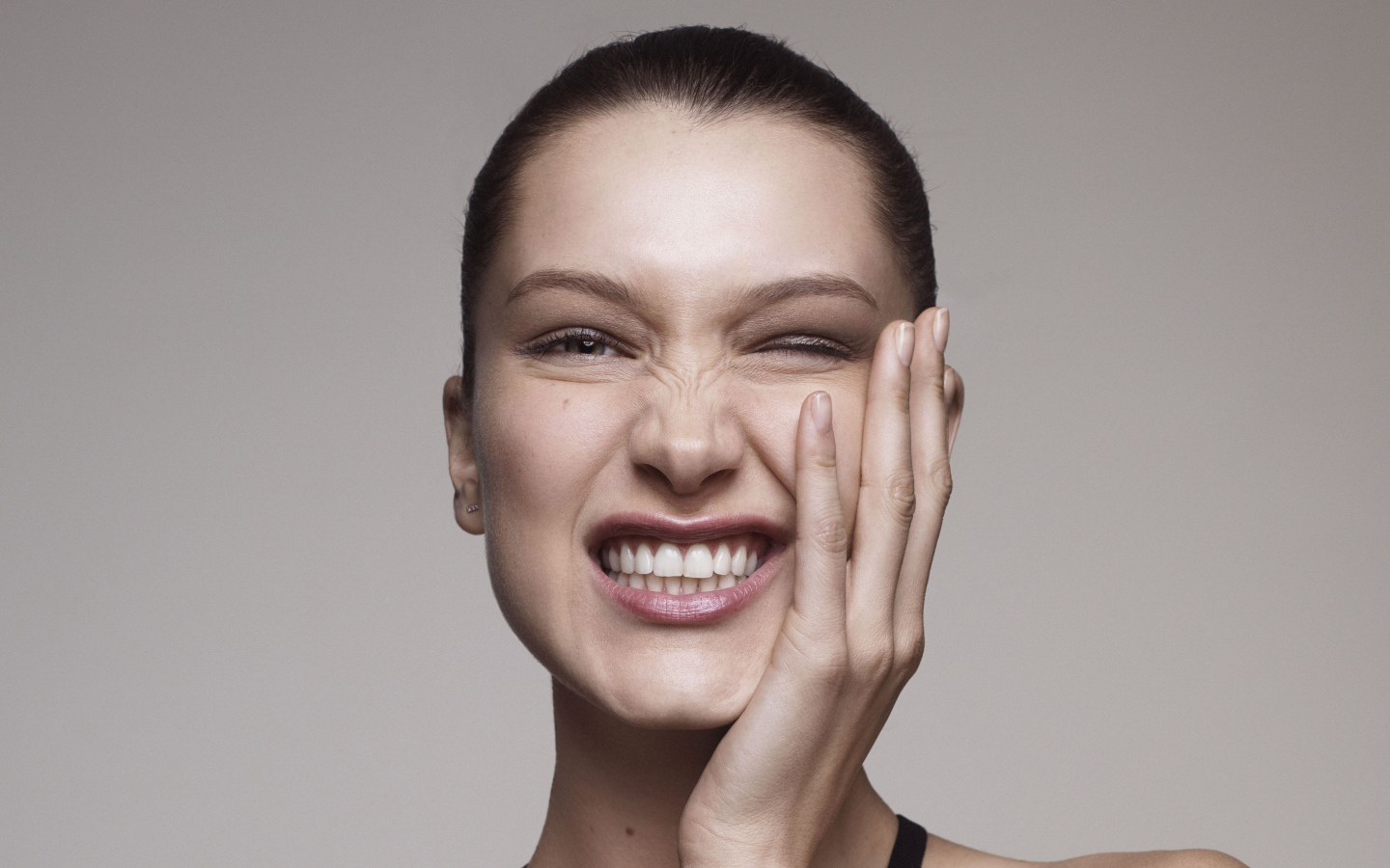 Модель Белла Хадид корчит гримасы на сером фоне