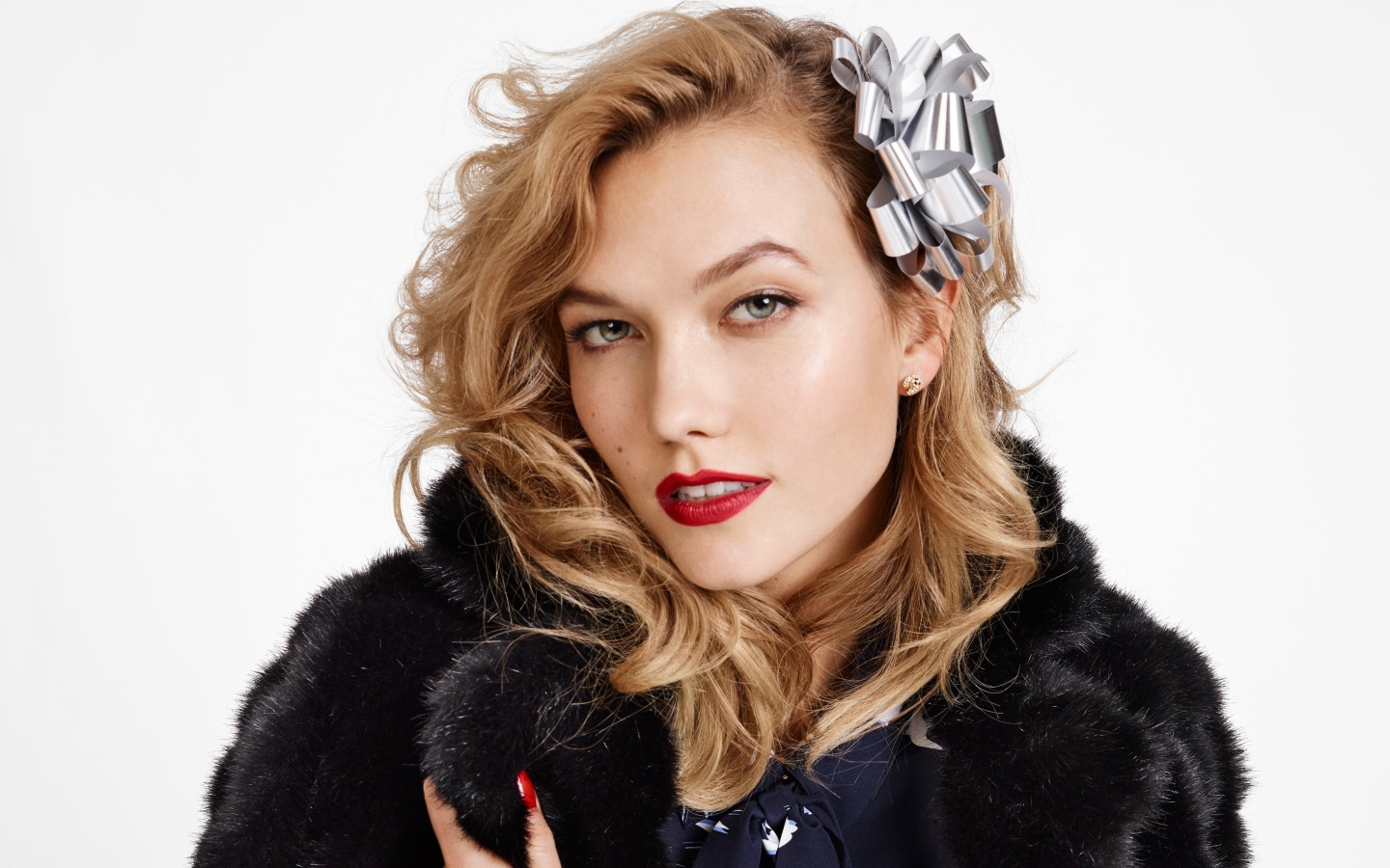 Модель Карли Клосс в черной шубе на белом фоне