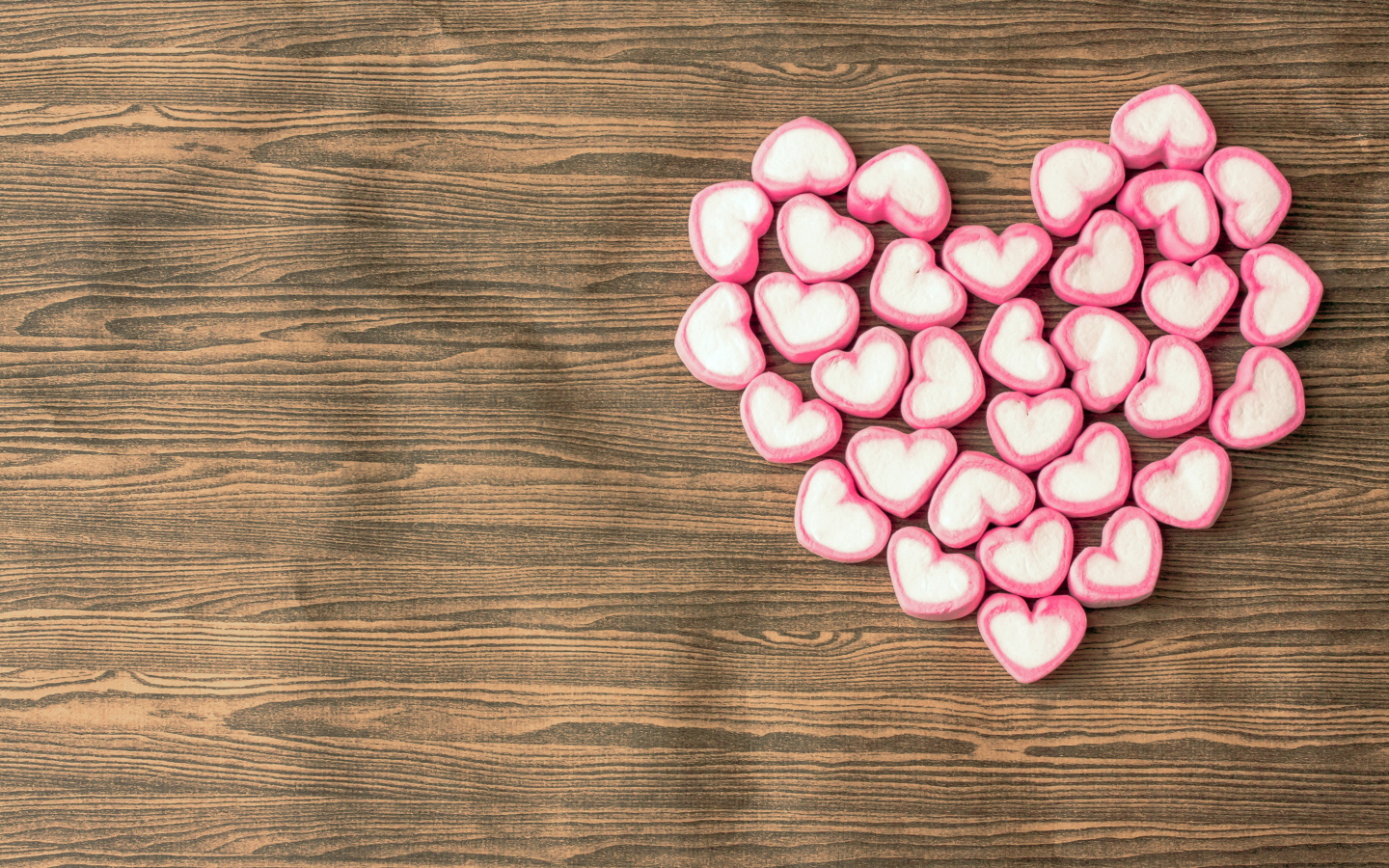 Сердце из конфет на деревянном столе