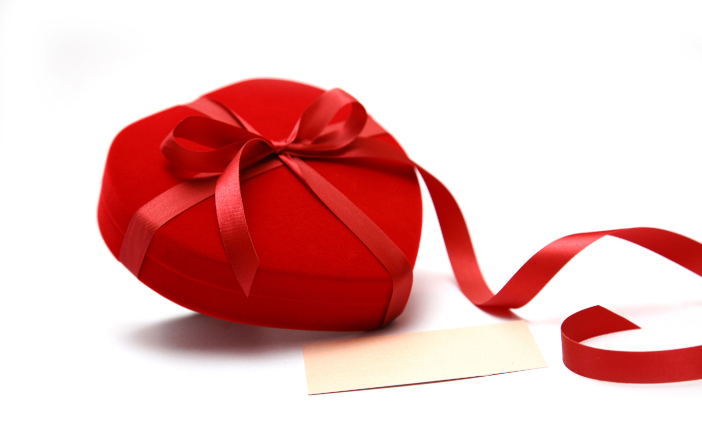 Красная коробка для ювелирных изделий в форме сердца на белом фоне 