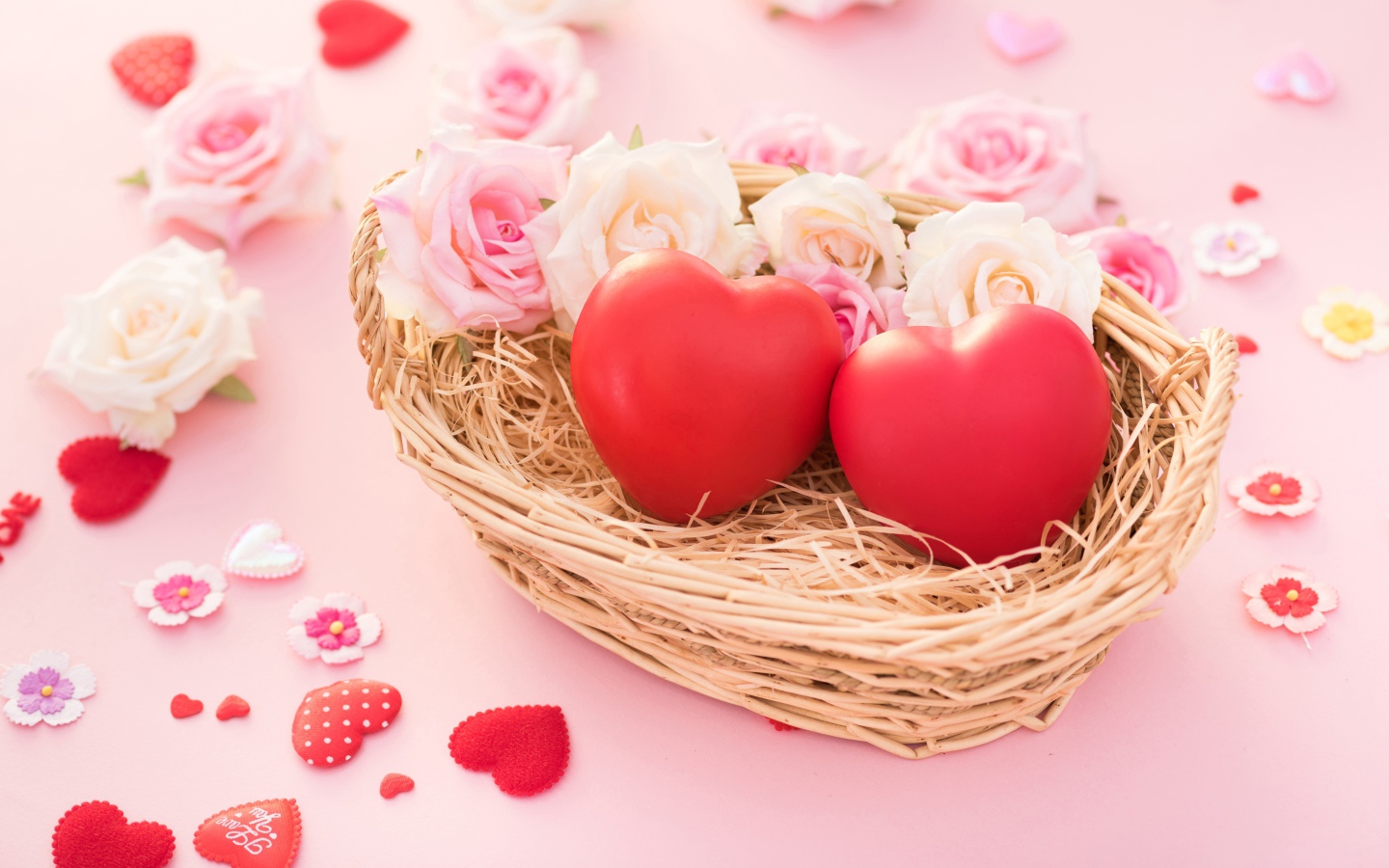 Два красных сердца лежат в корзинке с розами 