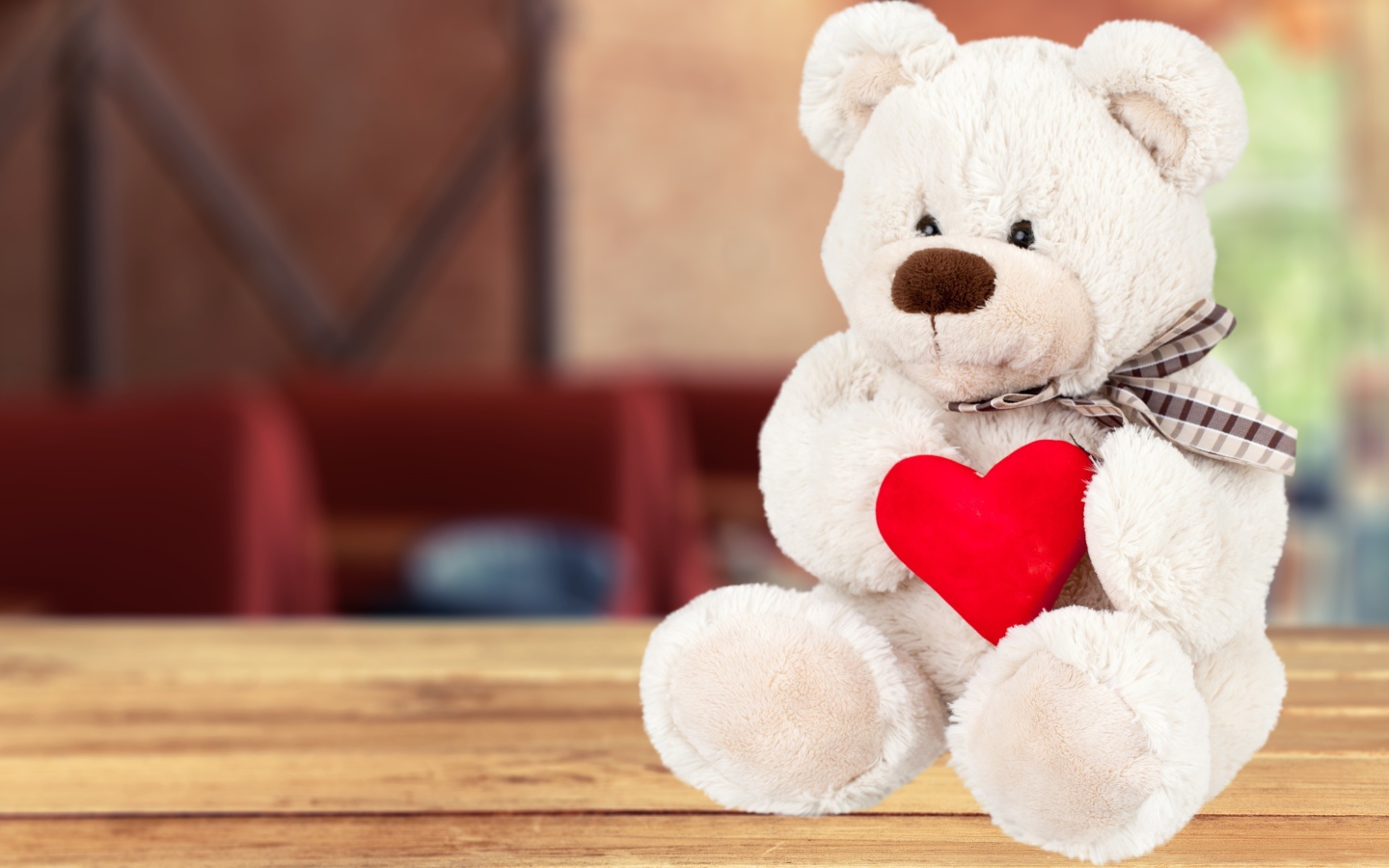 Белый плюшевый мишка с красным сердцем