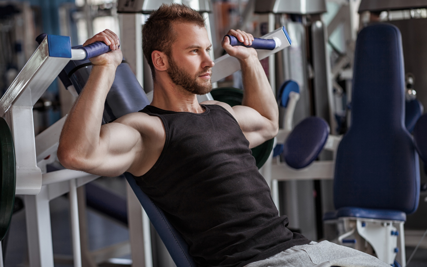 Накаченный мужчина занимается в спортзале