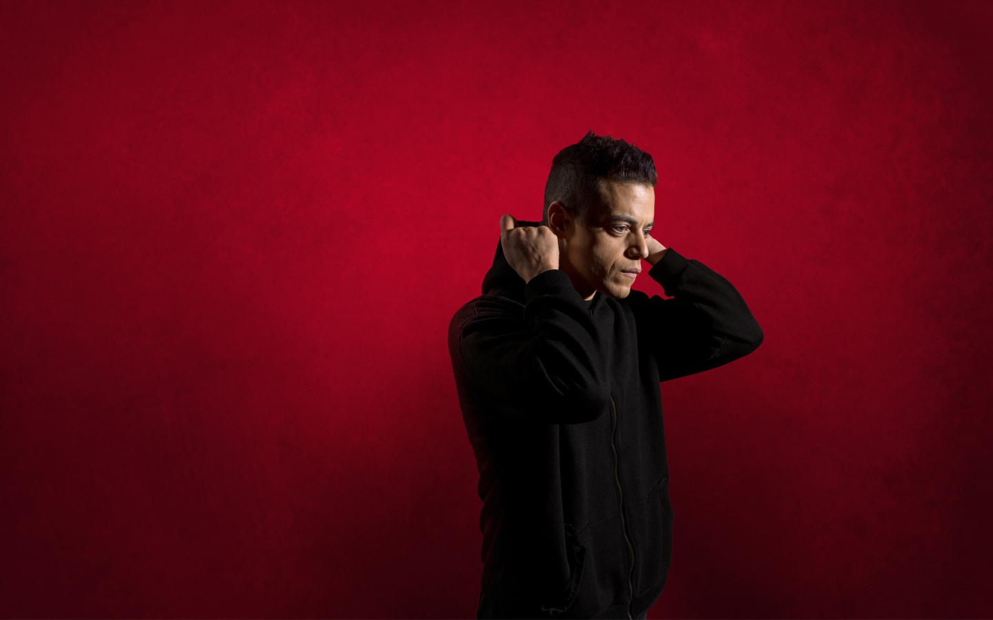 Актер Рами Малек на красном фоне