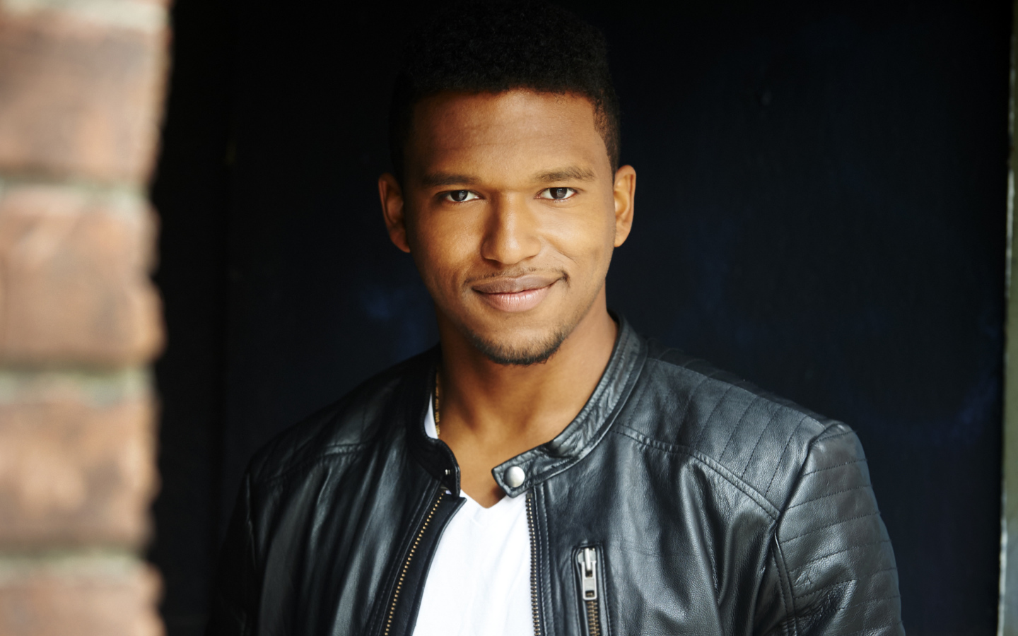 Красивый мужчина в черной куртке, актер Ловелл Адамс-Грей