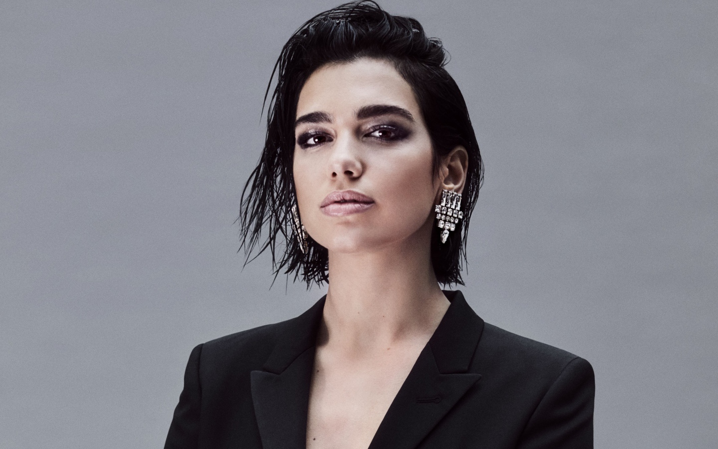 Стильная певица Дуа Липа на сером фоне