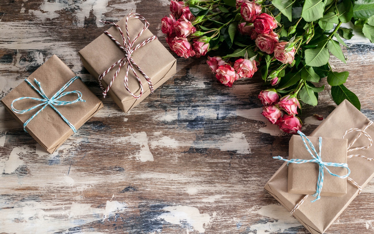 Подарочные коробки на деревянной поверхности с букетом роз