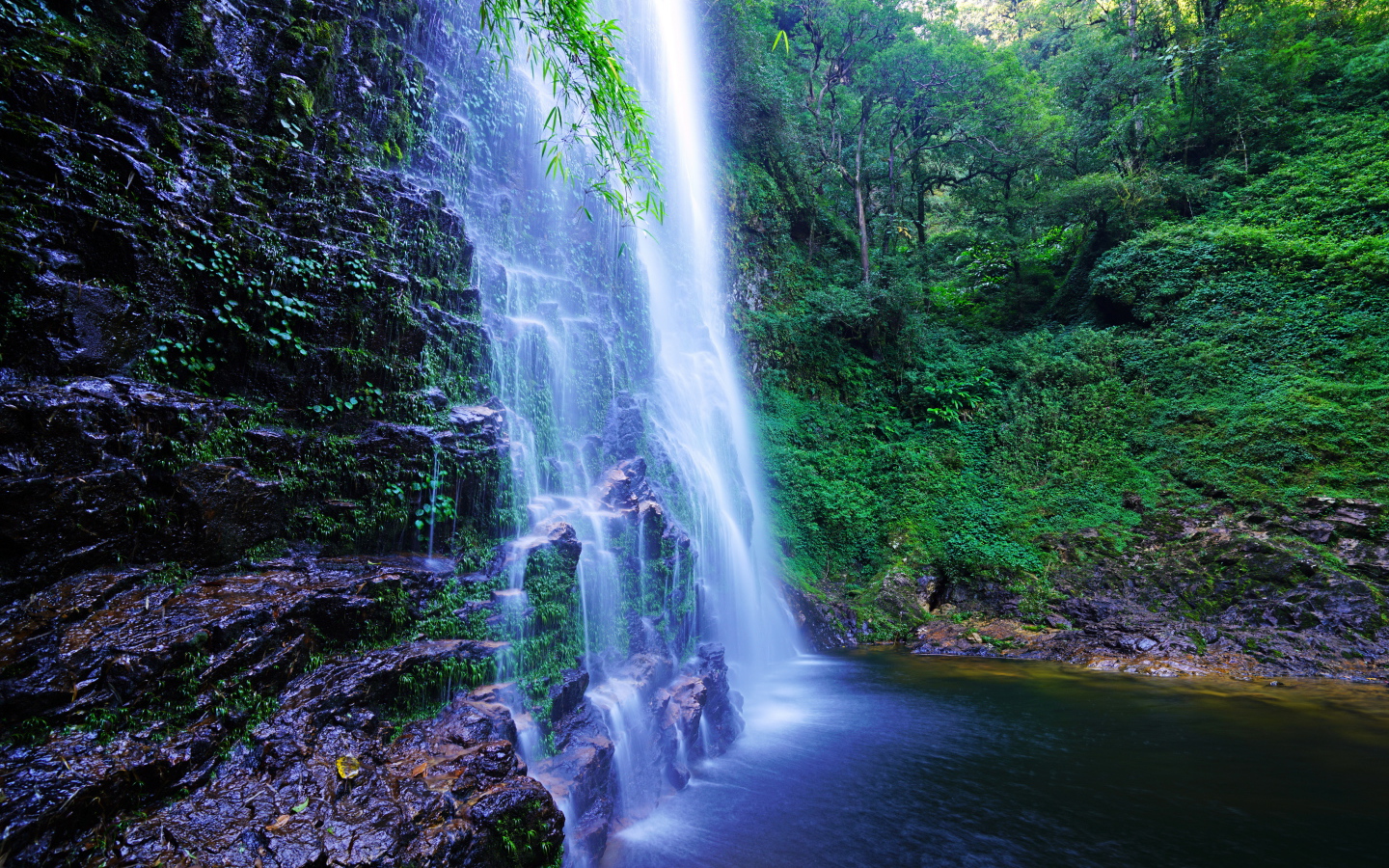 Быстрый водопад стекает по мокрым камням со скалы