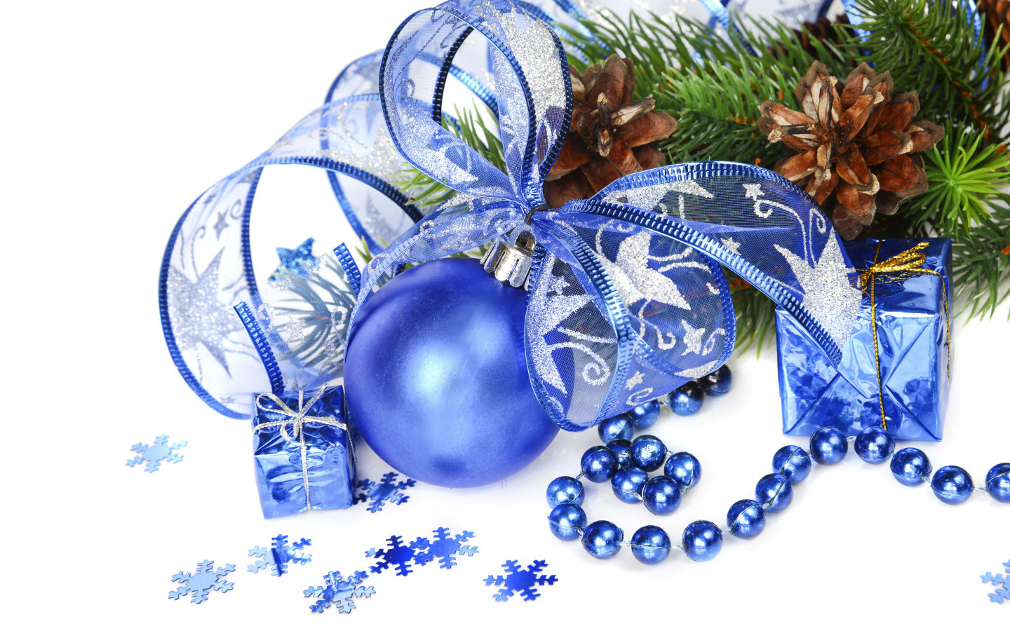 Красивый синий елочный шар с лентой на белом фоне с елочной веткой