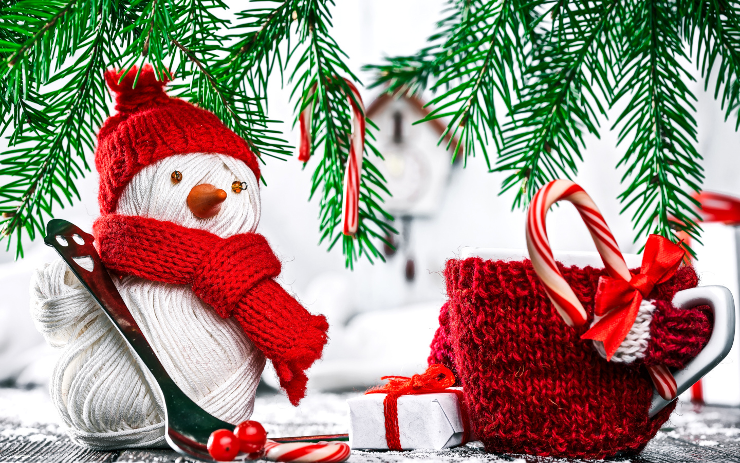 Снеговик из ниток на столе с чашкой и елочными ветками