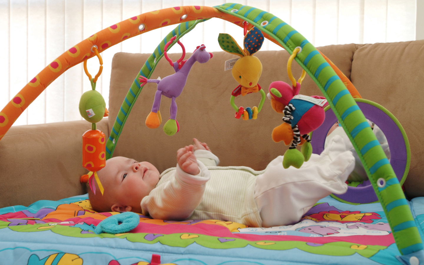 Грудной малыш играет с игрушками