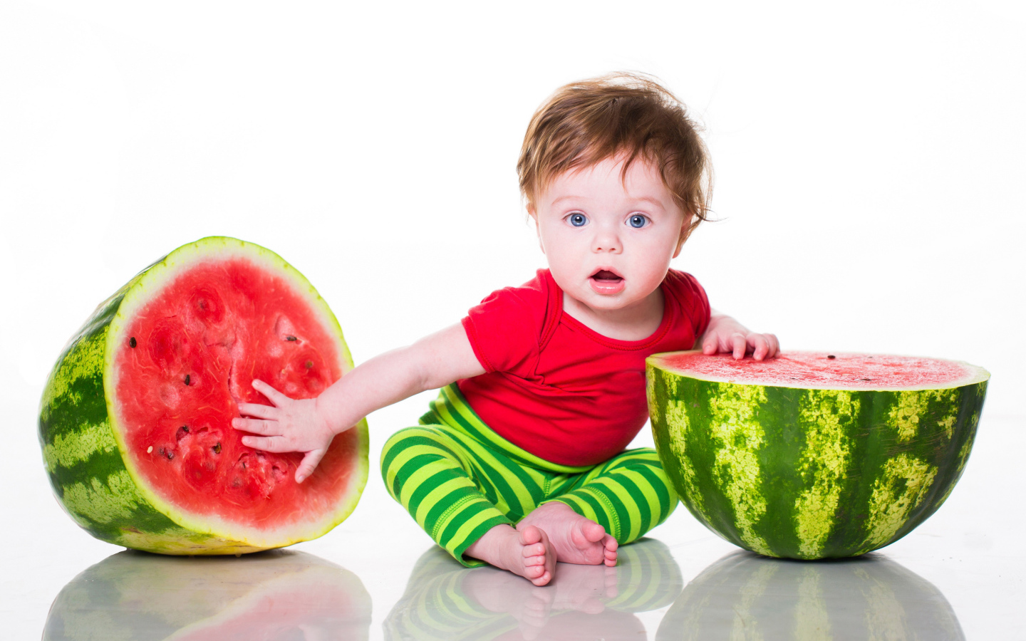 Милый голубоглазый мальчик с арбузом на белом фоне