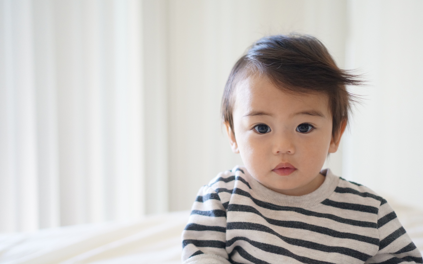 Маленький кареглазый мальчик в полосатом свитере