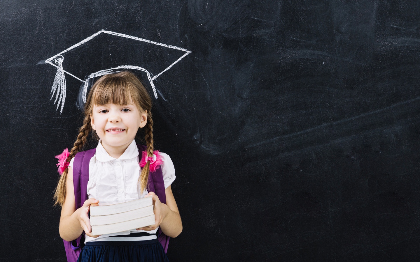 Маленькая школьница с книгами у доски 