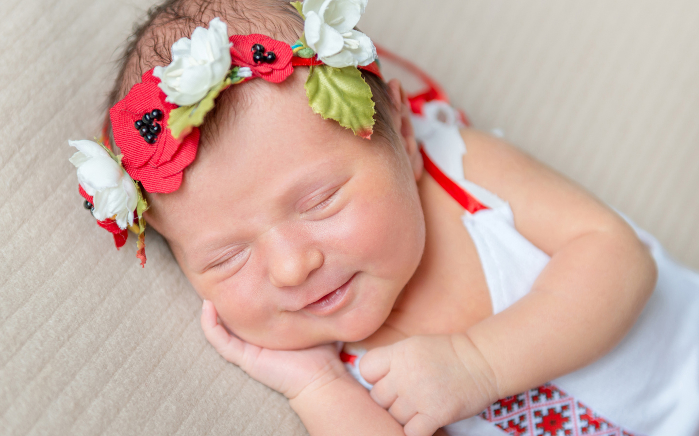 Улыбающаяся спящая девочка с венком на голове