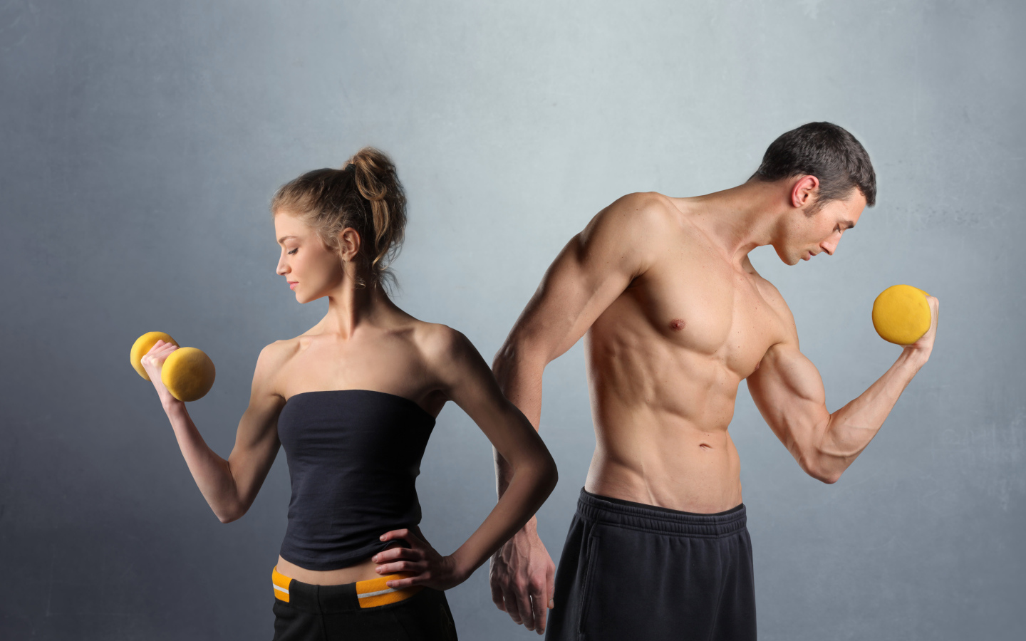 Девушка и парень занимаются спортом с гантелями