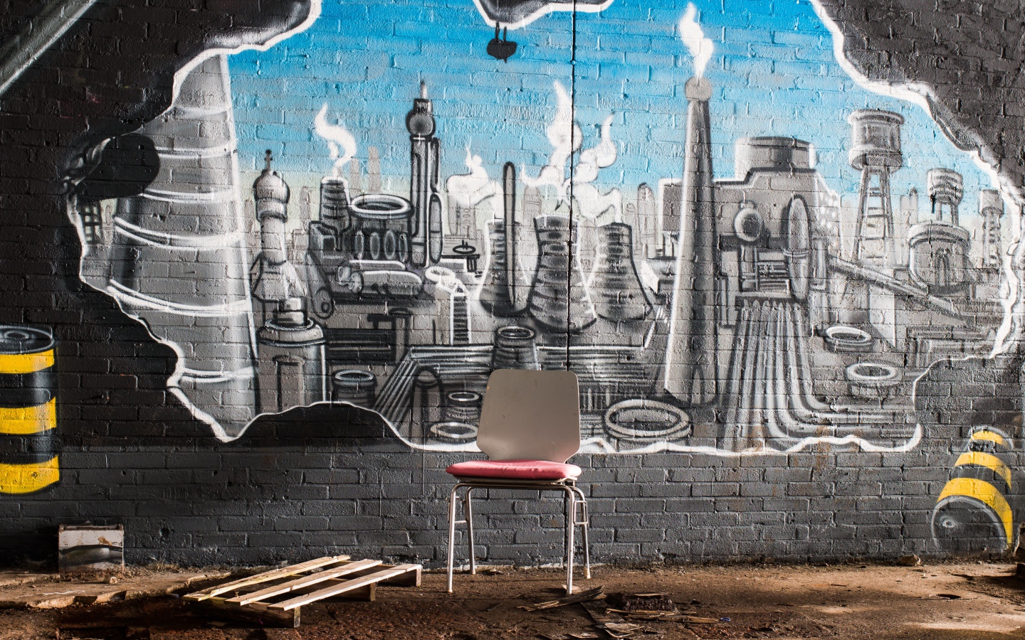 A chair stands by a brick wall with graffiti