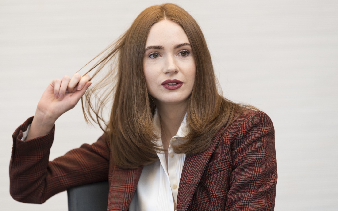 Актриса Карен Гиллан в пиджаке держит волосы