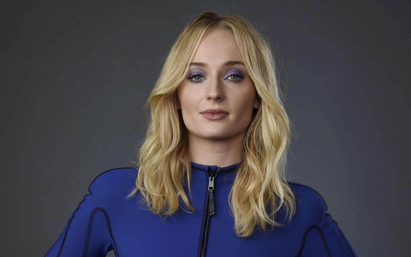 Актриса Софи Тернер крупным планом на сером фоне