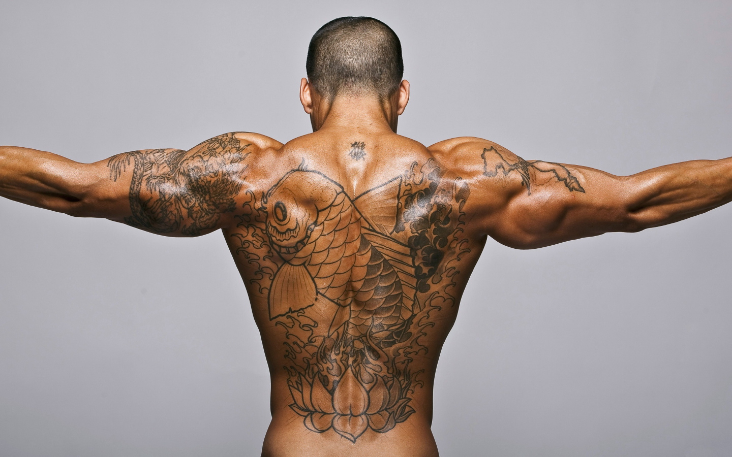 Big tattoo with a fish on the back of a man