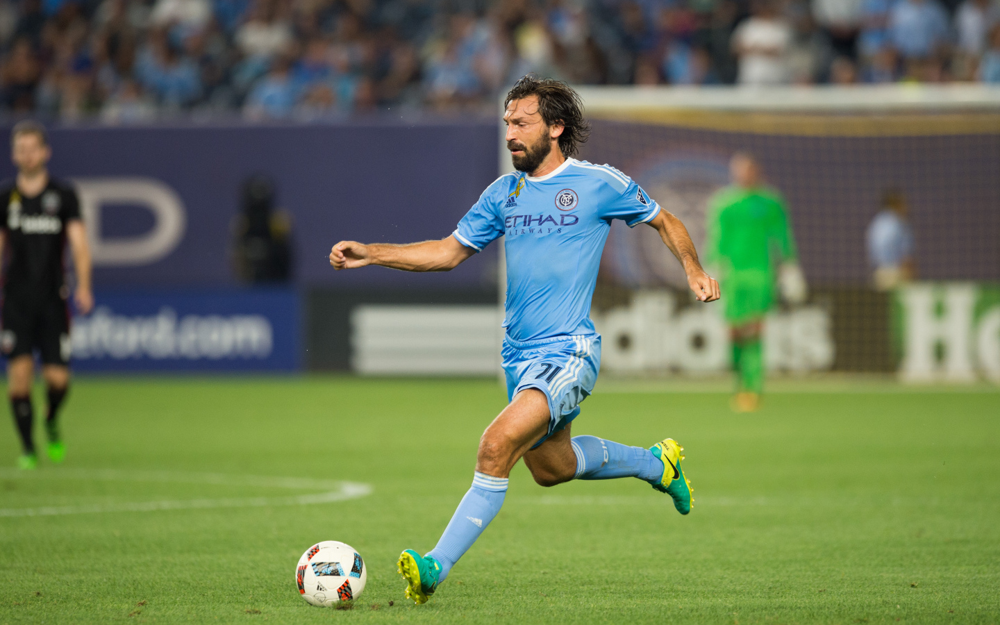 Итальянский футболист Андреа Пирло отбивает мяч на футбольном поле