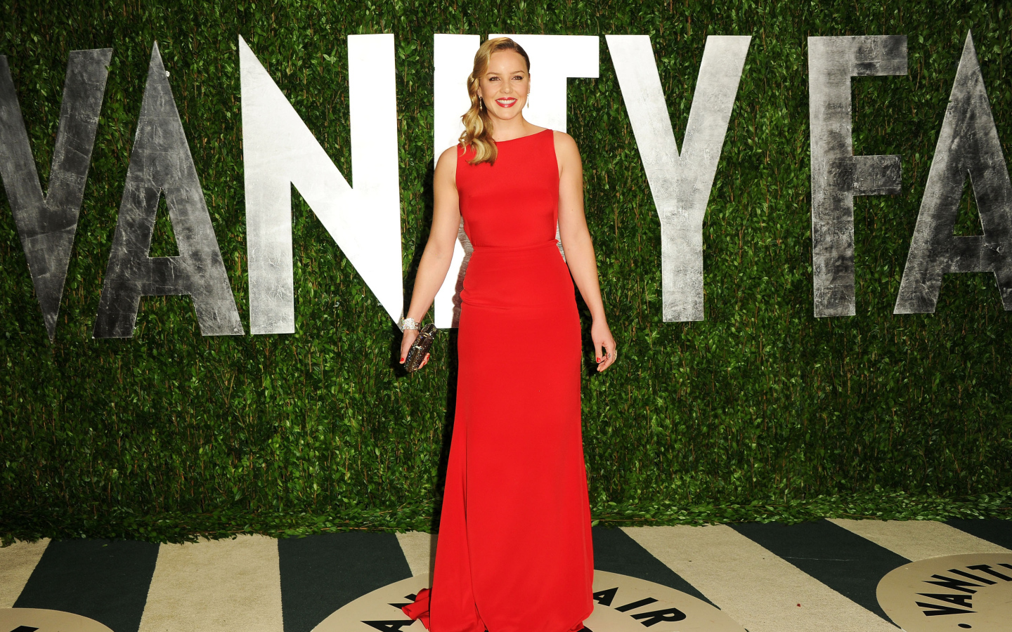 Улыбающаяся девушка, актриса Эбби Корниш в красном платье