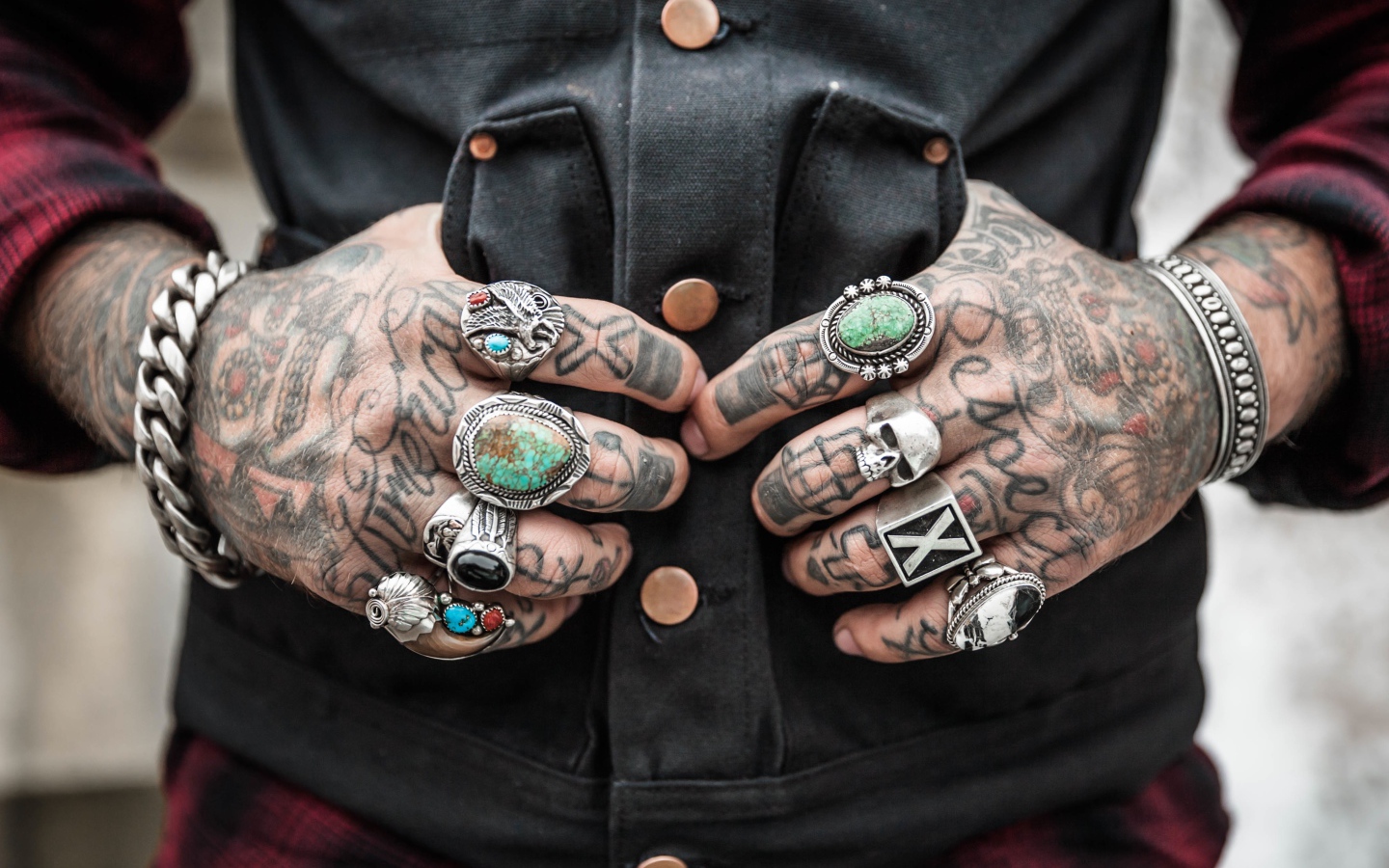 Татуировки на руках мужчины с перстнями