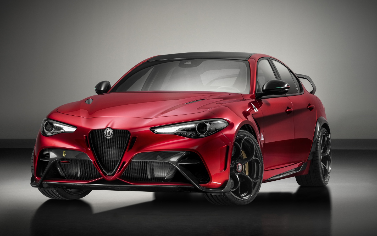 Красный автомобиль Alfa Romeo Giulia GTAm 2020 года на сером фоне