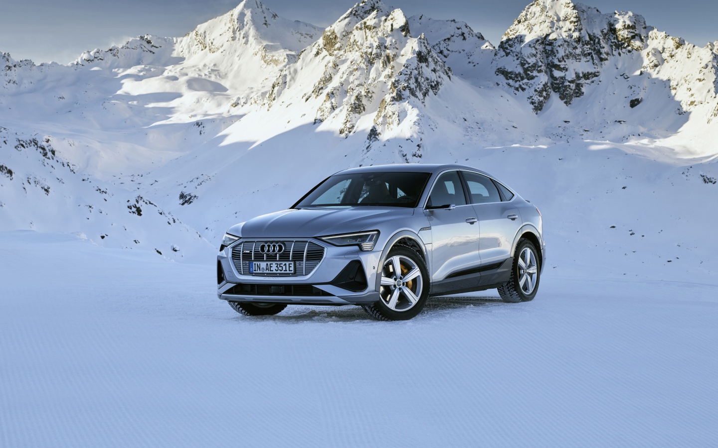Автомобиль Audi E-Tron 55 Quattro Sportback S Line, 2020 года на фоне заснеженных гор 