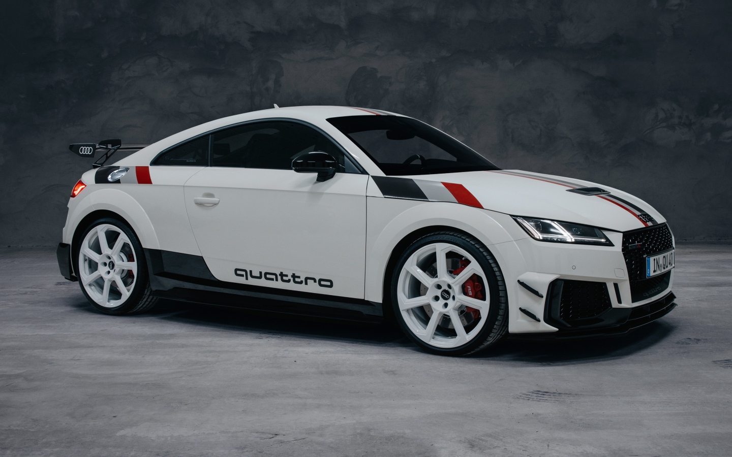 Белый автомобиль Audi TT RS Coupé 40 Jahre Quattro 2020 года на сером фоне