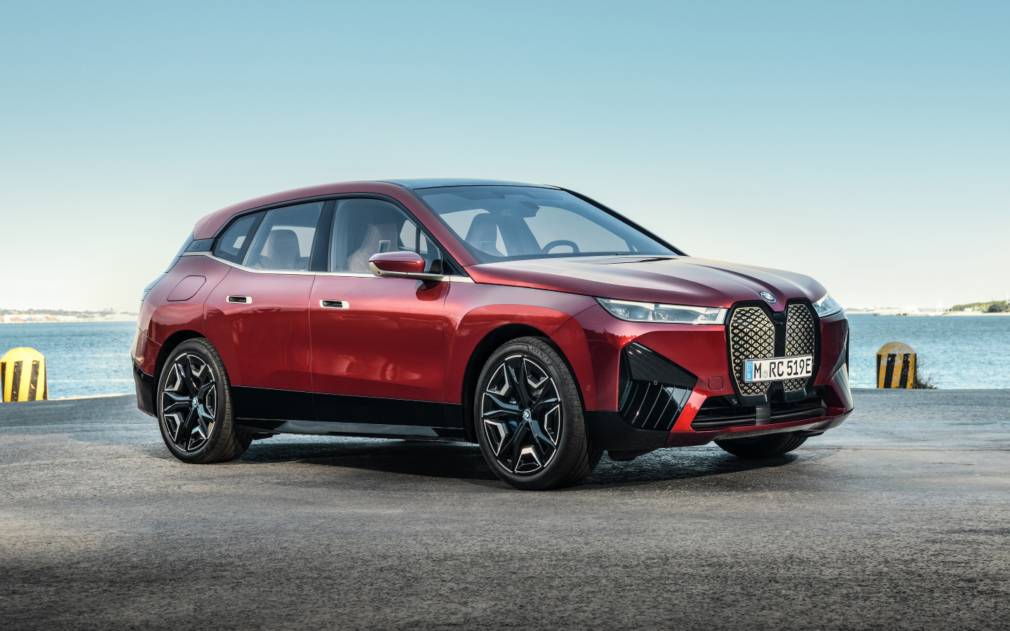 Бордовый автомобиль BMW IX 2021 года у воды